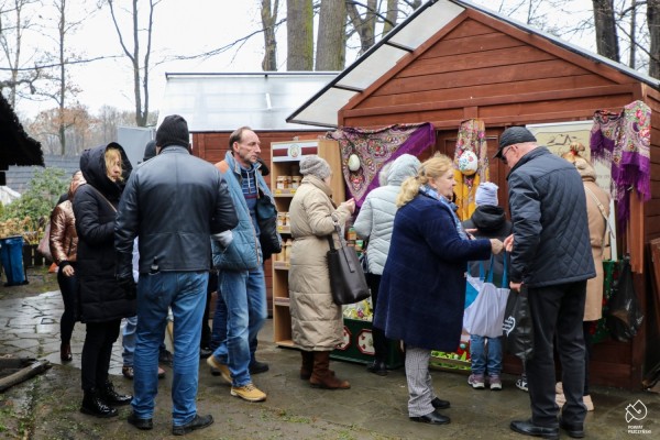 Stoiska - drewniane domki, przy stoiskach ludzie oglądają produkty