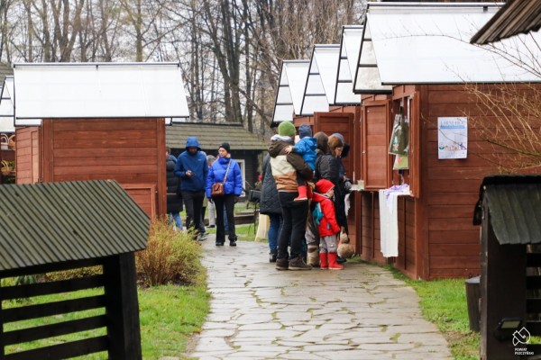 Stoiska - drewniane domki, przy stoiskach ludzie oglądają produkty