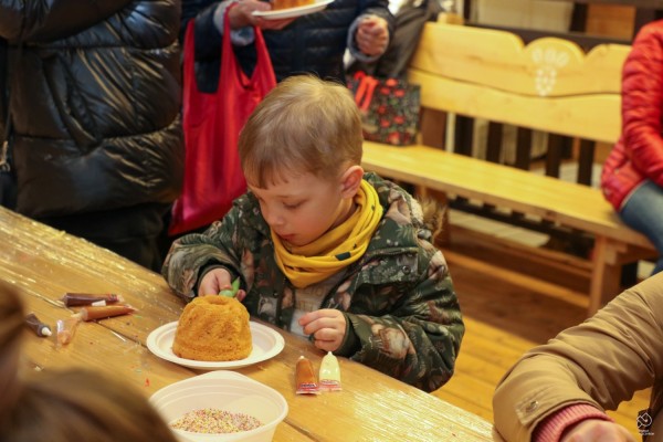 Chłopczyk dekoruje małą babkę wielkanocną