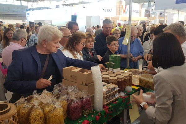 Stoisko Lokalnej Marki Ziemi Pszczyńskiej przy nim klienci.