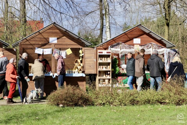 Ludzie oglądają produkty przy stoiskach z lokalnymi produktami.