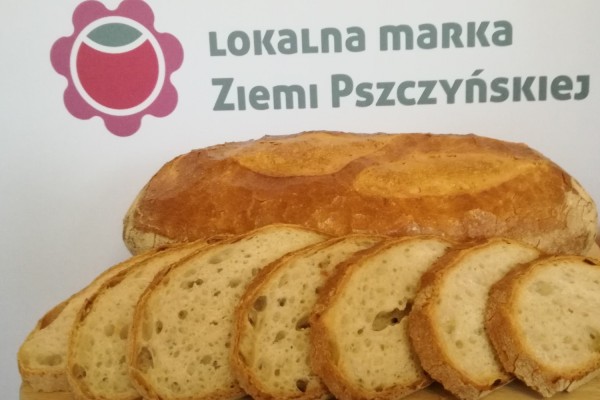 Certyfikowany chleb z łopaty. W tle logo Lokalnej Marki Ziemi Pszczyńskiej.