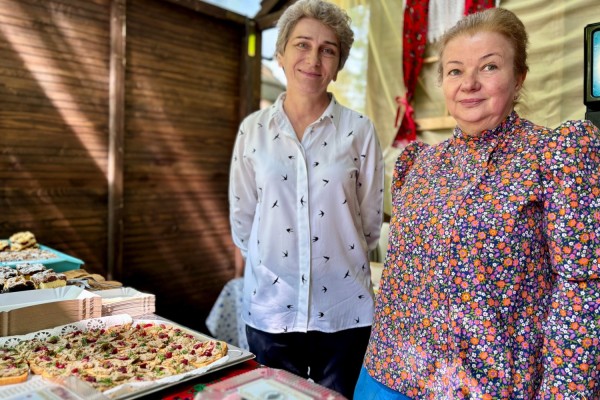 Przedstawicielki KGW Ćwiklice na stoisku ze swoimi produktami, jedna z pań ubrana w strój regionalny.