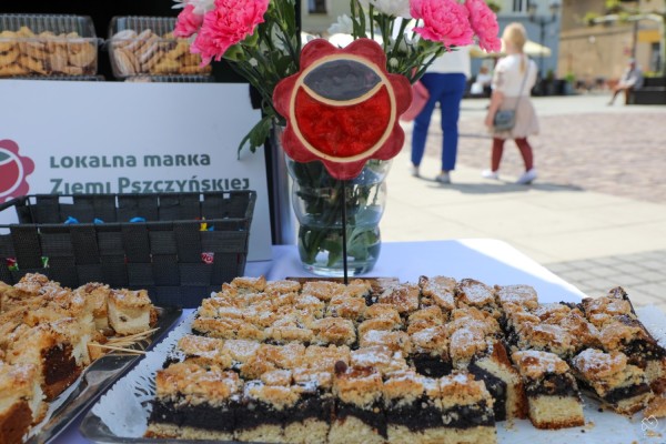 Tace z kołoczami, obok statuetka z logo Lokalnej Marki Ziemi Pszczyńskiej.