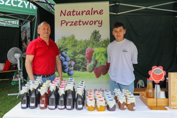 Przedstawiciele lokalnych producentów na stoisku ze swoimi produktami - sokami i przetworami.