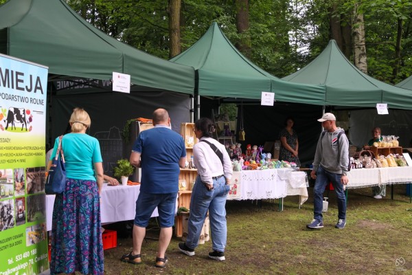 Osoby zainteresowane oglądają lokalne produkty na stoiskach.