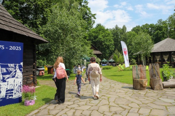 Osoby zwiedzające pszczyński skansen.